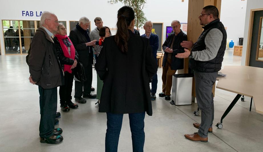 Group of visitors in the hall of an industrial site - see detailed description hereafter