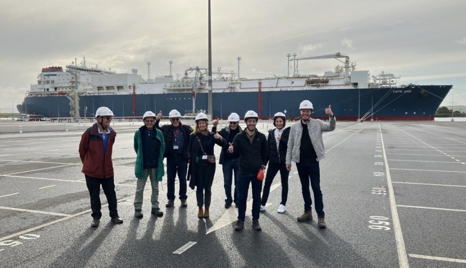 group of visitors in front of a boat in a port - see detailed description hereafter