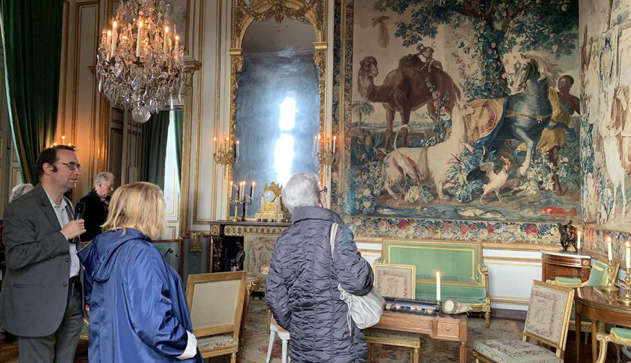  group of visitors observing a painting in a room - see detailed description hereafter