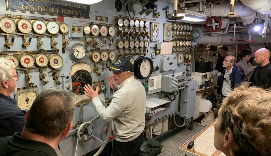 group of visitors in an engine room of a boat - see detailed description hereafter