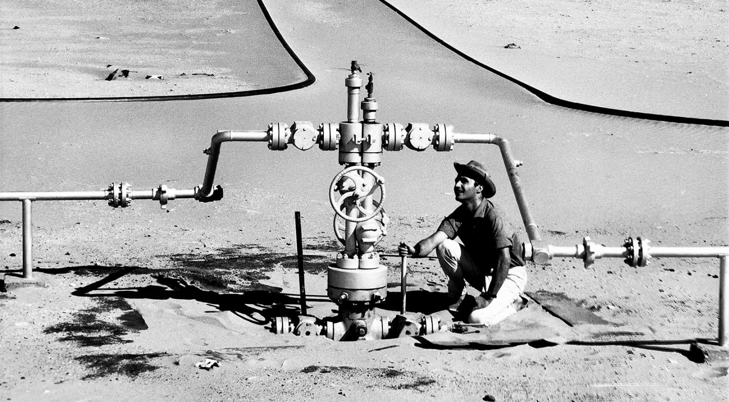 Compagnie de recherche et d'exploitation de pétrole au Sahara (CREPS) - Centrale de détente dans le Sahara - Relevé de pression effectué par un homme accroupi. Elf aquitaine