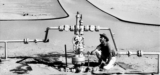 Compagnie de recherche et d'exploitation de pétrole au Sahara (CREPS) - Centrale de détente dans le Sahara - Relevé de pression effectué par un homme accroupi. Elf aquitaine